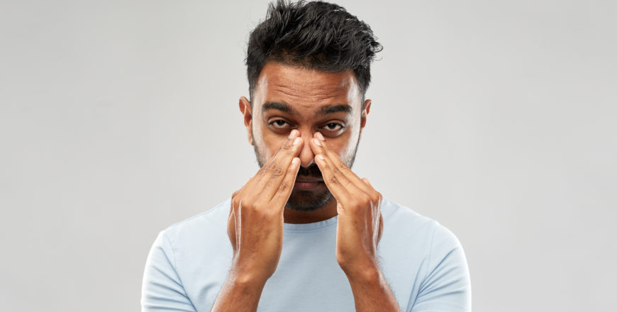 indian man rubbing nose